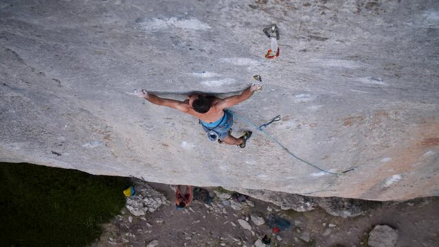 Young man lead climbing a hard and steep section of the wall in C&eacute;&uuml;se, France.
Following camera movement, low angle, 4K.