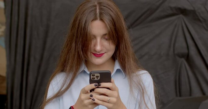 Young Woman looking at smartphone screen, access social media platforms, check notifications. Checking Social Apps. Checking bank accounts, making payments, or managing finances through banking apps. 