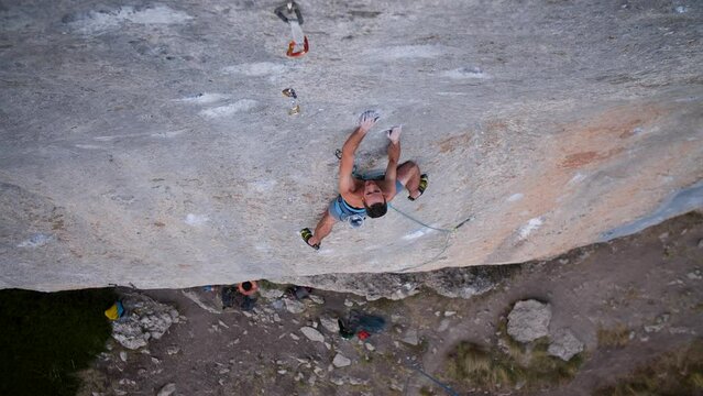 Young man lead climbing a hard and steep section of the wall in C&eacute;&uuml;se, France.
Following camera movement, low angle, 4K.