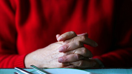 Close-up of senior hands clenched together in thought, Detail of hand capturing a moment of...