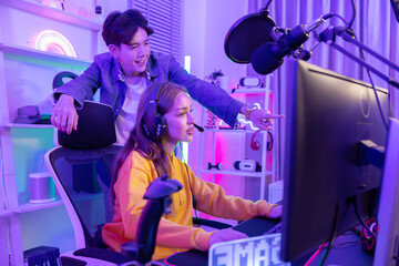 Asian male mentor advice young woman to fight in esport tournament © charnsitr