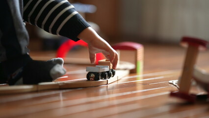 Child's hands playing with Antique Train Toy, Youngster Engaged with Railway Set Indoors, candid kid plays by himself at home