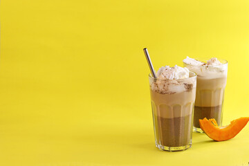 coffee with cream in a glass glass on a yellow background