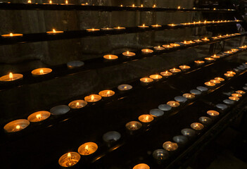 votive candles lit by the faithful after reciting a prayer inside the Church