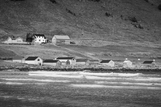 Panoramic Black and White View of Maloy Coastline: Waves, Rustic Houses, and Mountains