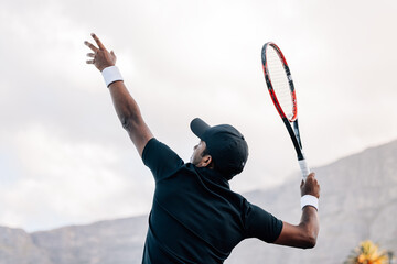 Tennis player hitting a serve. Young tennis player about to hit the ball. - Powered by Adobe