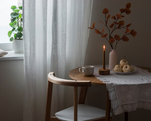 Cozy autumn house. Autumn decor, candle on a round wooden table in the living room