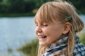A girl of 10-12 years old sincerely laughs and enjoys life, relaxing in nature. The child...