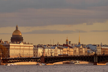 Fototapeta premium Automobile iron vintage bridge across the river of a European city, in autumn at sunset.