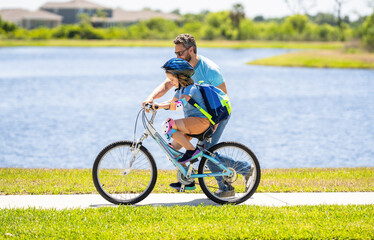 Fototapeta premium father teaching his son to ride a bicycle. ride fast. father and son outdoor. father and son enjoying a bicycle ride together. active son and father duo cycling through scenic countryside on bicycle