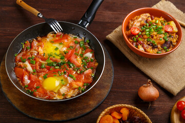 Jewish food hot cholent and shakshuka on a laid Shabbat table.