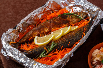 Fish baked whole with a head in lemon juice on a pillow of carrots for Rosh Hashanah.