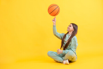 Fototapeta premium Skilled teen girl playing the basketball. Competitive teen girl playing basketball. teen girl practicing basketball skills. Teen girl excelling in basketball. Nurturing talent in childhood sports