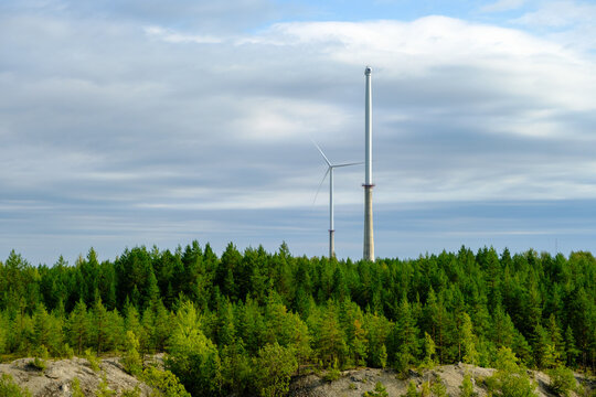 This is a former shale quarry with azure water and picturesque hills. Unlike the Narva shale settling ponds. A dark autumn day. Estonia, Aidu quarry. A tall wind turbine in the distance