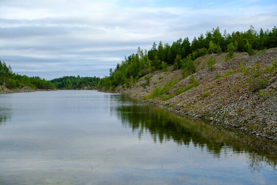 This is a former shale quarry with azure water and picturesque hills. Unlike the Narva shale settling ponds. A dark autumn day. Estonia, Aidu quarry.