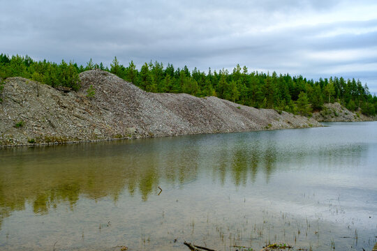 This is a former shale quarry with azure water and picturesque hills. Unlike the Narva shale settling ponds. A dark autumn day. Estonia, Aidu quarry.