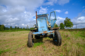 Fototapeta premium Old blue Russian agricultural tractors in the field. Agricultural machinery in the farm. Special Agricultural Equipment. Durable agricultural machinery