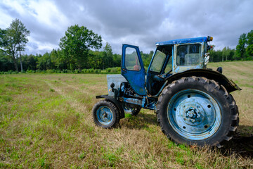 Old blue Russian agricultural tractors in the field. Agricultural machinery in the farm. Special Agricultural Equipment. Durable agricultural machinery