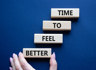 Time to feel better symbol. Wooden blocks with words Time to feel better. Businessman hand. Beautiful deep blue background. Medicine and Time to feel better concept. Copy space.