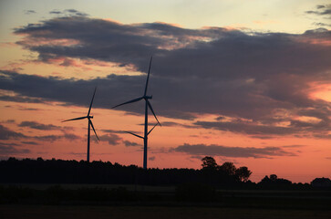 Obraz premium wind generators against the sky at sunset