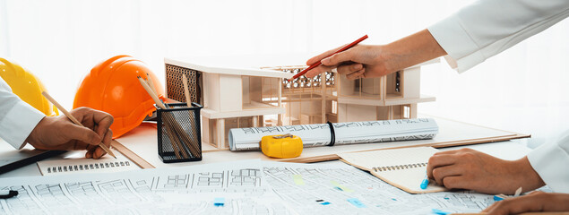 Worker, architect and engineer work on real estate construction project oratory planning with...