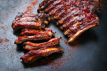 Barbecue veal spare loin ribs St Louis cut with hot honey chili sauce served as close-up on a rustic black board