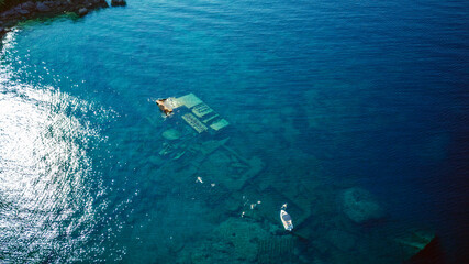 Aerial view of people swimming above sunken shipwreck of cargo ship Boka, now tourist attraction,...