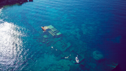 Aerial view of people swimming above sunken shipwreck of cargo ship Boka, now tourist attraction,...
