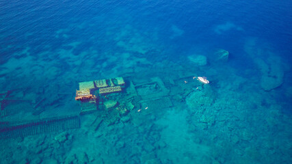 Aerial view of people swimming above sunken shipwreck of cargo ship Boka, now tourist attraction,...