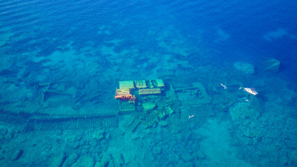 Aerial view of people swimming above sunken shipwreck of cargo ship Boka, now tourist attraction,...