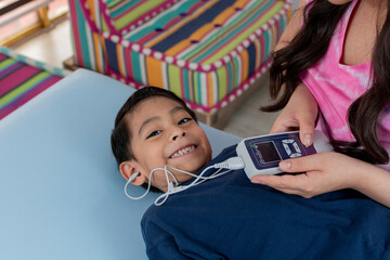 A child smiling at the camera while having a hearing test ,hearing screen, in the pediatric office, with copy space