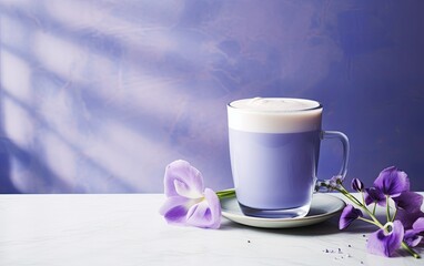 Obraz na płótnie Canvas Blue matcha smoothie in a glass mug on a table decorated with butterfly pea flowers