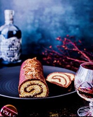 Glass of rum and christmas chocolate roulade image on a blue dark background 