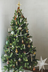 Stylish decorated christmas tree with vintage golden baubles, candles and festive lights....