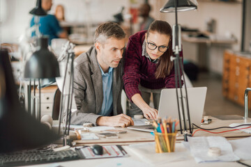 Diverse group of designers working on a laptop in a startup company office