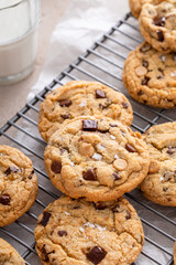 Chocolate chip cookies on a cooling rack with flaky salt served with milk