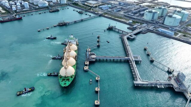 LNG (Liquefied natural gas) tanker anchored in Gas terminal gas tanks for storage. Oil Crude Gas Tanker Ship. LPG at Tanker Bay Petroleum Chemical or Methane freighter export import transportation	