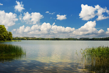 Lake landscape. Summer time background. Szelment Wielki lake in Poland. Blue cloudy sky over water surface panoramic view. Tranquil rural view. Weekend camping.