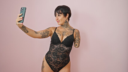 Hispanic woman with amputee arm wearing lingerie make selfie by smartphone smiling over isolated...