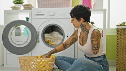 Hispanic woman with amputee arm washing clothes sitting on floor at laundry room