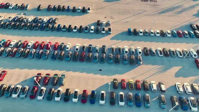 Large parking lot of local dealer with many brand new cars parked for sale. Development of american automotive industry and distribution of manufactured vehicles concept