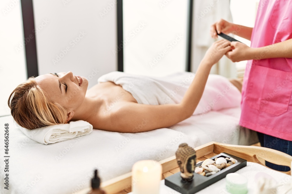 Canvas Prints Young caucasian woman lying on table having manicure treatment at beauty salon