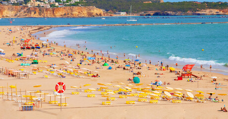 public beach in portugal on hot sunny day.