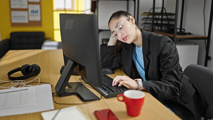 Young beautiful hispanic woman business worker tired using computer working at office