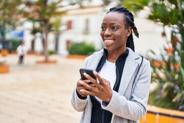 African american woman smiling confident using smartphone at park