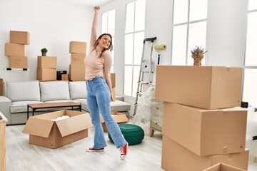 Fototapeta premium Young beautiful hispanic woman smiling confident standing at new home