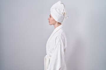Blonde caucasian woman wearing bathrobe looking to side, relax profile pose with natural face and confident smile. - obrazy, fototapety, plakaty