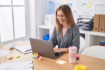 Young blonde woman business worker using laptop working at office