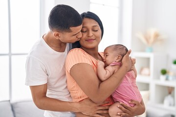 Fototapeta premium Hispanic family hugging each other kissing at home
