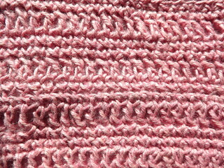 A sample crocheted from pink jute close-up on a gray background